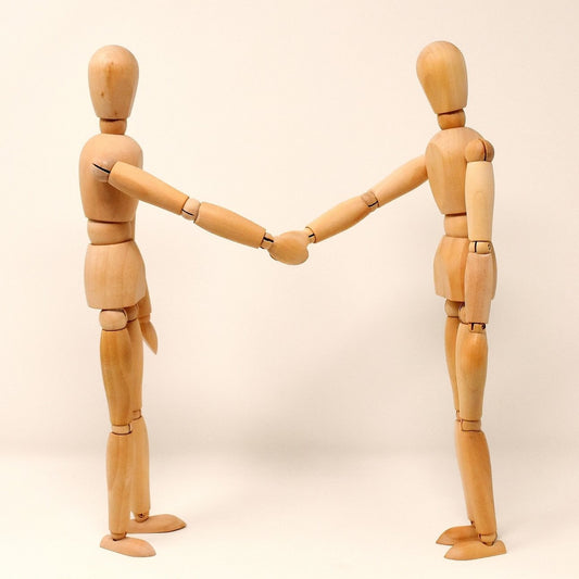 Photo of two art mannequins shaking hands